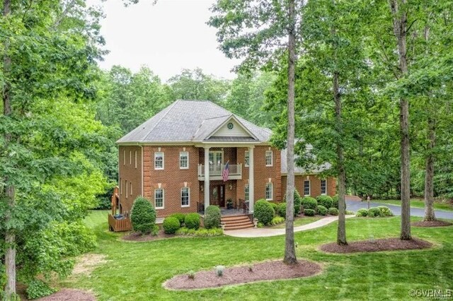 1638 Fallen Timber Trl, Powhatan, VA 23139 - greek revival house featuring a balcony, a front yard, brick siding, and view of scattered trees