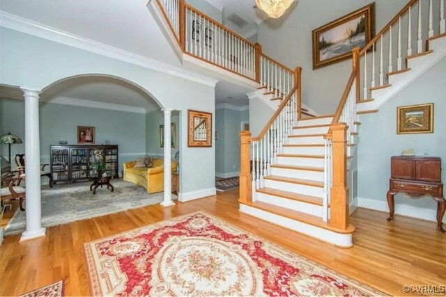 1638 Fallen Timber Trl, Powhatan, VA 23139 - entrance foyer with decorative columns, wood finished floors, arched walkways, stairway, and ornamental molding