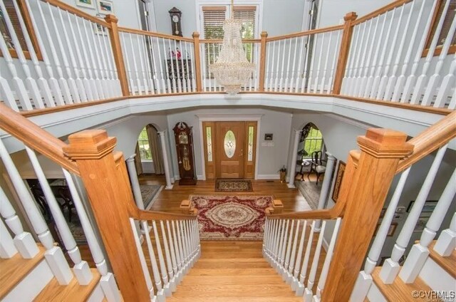 1638 Fallen Timber Trl, Powhatan, VA 23139 - foyer entrance featuring wood finished floors, stairway, a chandelier, arched walkways, and a high ceiling