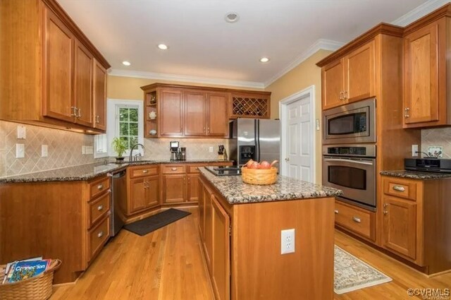 1638 Fallen Timber Trl, Powhatan, VA 23139 - kitchen featuring stainless steel appliances, dark stone countertops, light wood-style floors, brown cabinetry, and open shelves