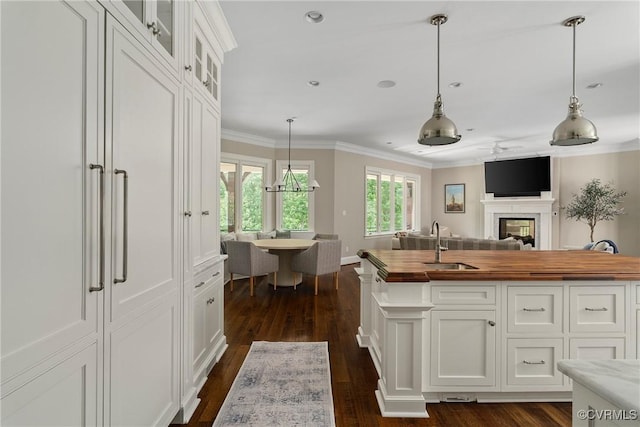 923 Merchant Lee Pl, Manakin Sabot, VA 23103 - kitchen with wooden counters, dark wood-style flooring, glass insert cabinets, white cabinets, and ornamental molding