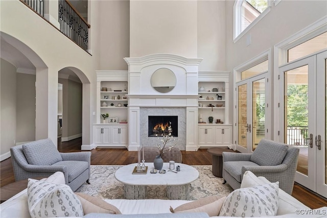 923 Merchant Lee Pl, Manakin Sabot, VA 23103 - living room featuring a high ceiling, dark wood-type flooring, arched walkways, french doors, and a fireplace