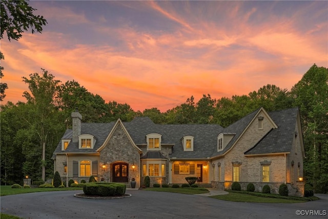 923 Merchant Lee Pl, Manakin Sabot, VA 23103 - french country style house featuring stone siding, a chimney, french doors, curved driveway, and a high end roof