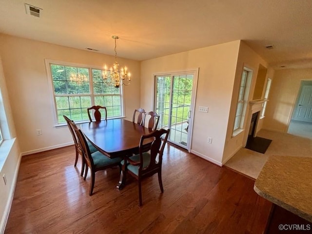 4000 Rotherham Cir, Prince George, VA 23875 - dining area featuring dark wood-style floors, a chandelier, and a fireplace with flush hearth