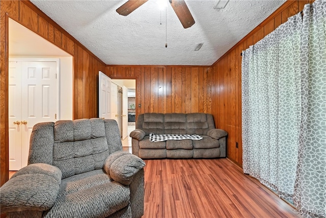 1593 Baxter Rd, Prince George, VA 23875 - living area with a ceiling fan, wood finished floors, a textured ceiling, and wooden walls