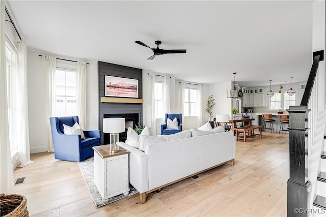 3013 Swanns Inn Cres, Goochland, VA 23063 - living room featuring a ceiling fan, a fireplace, light wood-style floors, and plenty of natural light