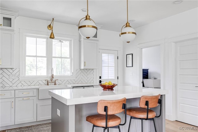 3013 Swanns Inn Cres, Goochland, VA 23063 - kitchen with tasteful backsplash, light countertops, a kitchen bar, and a kitchen island