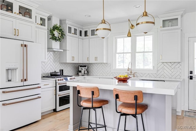 3013 Swanns Inn Cres, Goochland, VA 23063 - kitchen featuring white appliances, light countertops, a breakfast bar area, and recessed lighting