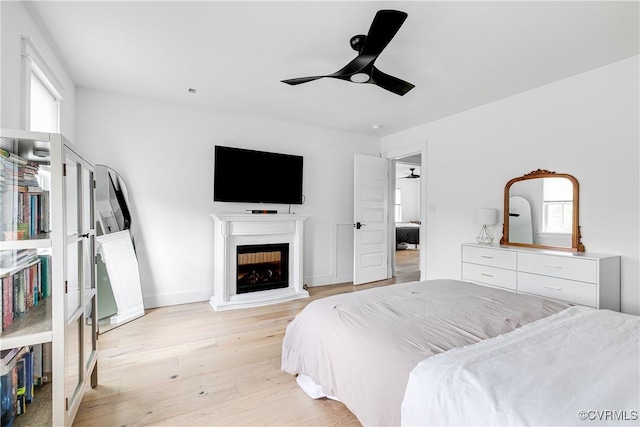 3013 Swanns Inn Cres, Goochland, VA 23063 - bedroom with light wood-style floors, a fireplace, and a ceiling fan