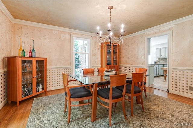 12103 Wexwood Pl, North Chesterfield, VA 23236 - dining room with a chandelier, wood finished floors, a wainscoted wall, wallpapered walls, and crown molding