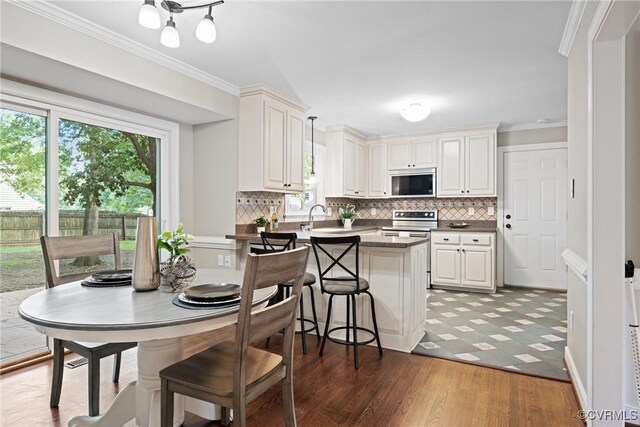 2801 Aspinwald Dr, Henrico, VA 23233 - kitchen with electric stove, a peninsula, ornamental molding, tasteful backsplash, and healthy amount of natural light