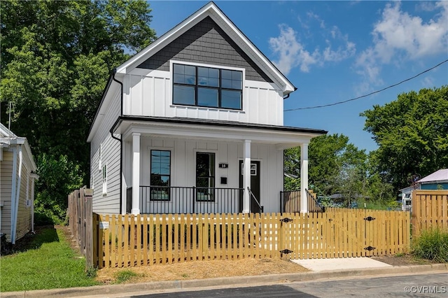 18 W 29th St, Richmond, VA 23223 - view of front of home with board and batten siding, a porch, a fenced front yard, and a gate