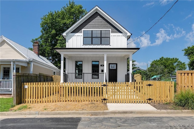 18 W 29th St, Richmond, VA 23223 - view of front of property with a porch, board and batten siding, a fenced front yard, and a gate