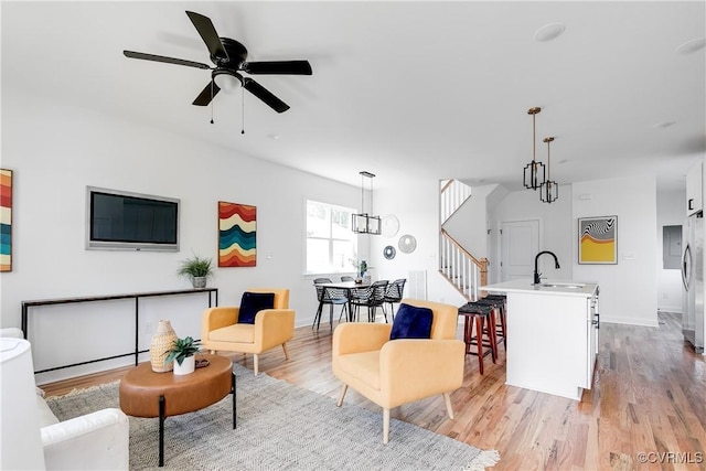 18 W 29th St, Richmond, VA 23223 - living room with stairway, light wood-type flooring, a ceiling fan, and a chandelier