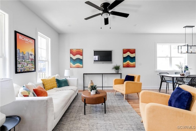 18 W 29th St, Richmond, VA 23223 - living room with wood finished floors, a ceiling fan, and a chandelier