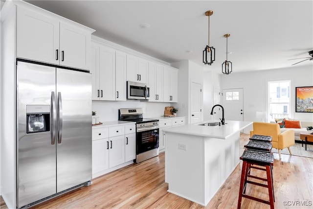 18 W 29th St, Richmond, VA 23223 - kitchen with stainless steel appliances, light wood finished floors, open floor plan, and white cabinetry