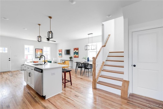 18 W 29th St, Richmond, VA 23223 - kitchen with dishwasher, a kitchen bar, a center island with sink, light wood-type flooring, and pendant lighting