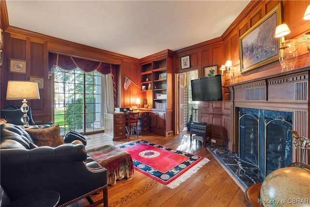 985 Kingston Ln, North, VA 23128 - living area featuring a fireplace, wood finished floors, wood walls, built in features, and ornamental molding