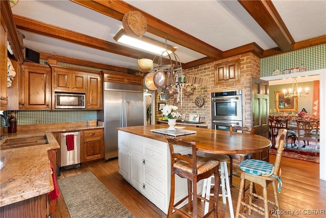 985 Kingston Ln, North, VA 23128 - kitchen with built in appliances, a chandelier, beamed ceiling, wood finished floors, and decorative backsplash