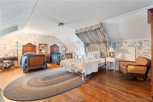 985 Kingston Ln, North, VA 23128 - bedroom with wallpapered walls, vaulted ceiling, wood finished floors, and a textured ceiling