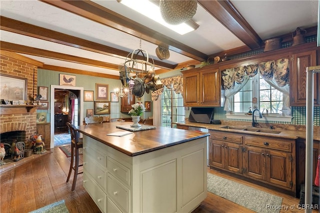985 Kingston Ln, North, VA 23128 - kitchen with wood-type flooring, plenty of natural light, beam ceiling, and a brick fireplace