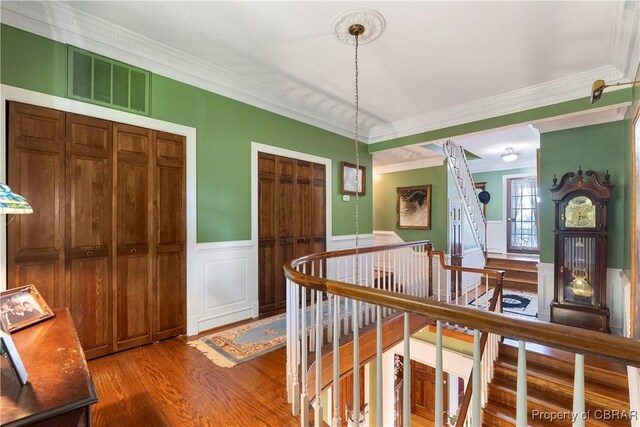 985 Kingston Ln, North, VA 23128 - hallway with wood finished floors, an upstairs landing, ornamental molding, a wainscoted wall, and a decorative wall