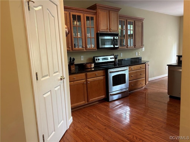 5623 Virginia Park Dr, Providence Forge, VA 23140 - kitchen featuring appliances with stainless steel finishes, brown cabinetry, dark wood finished floors, and glass insert cabinets