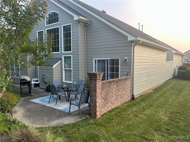 5623 Virginia Park Dr, Providence Forge, VA 23140 - back of property at dusk with a patio area and a lawn