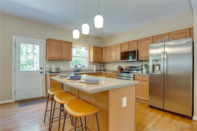 8750 Springwater Dr, Henrico, VA 23228 - kitchen with stainless steel appliances, light wood finished floors, light countertops, a center island, and a breakfast bar
