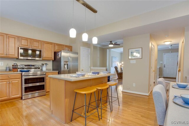 8750 Springwater Dr, Henrico, VA 23228 - kitchen featuring appliances with stainless steel finishes, light wood-type flooring, a kitchen bar, a kitchen island, and pendant lighting