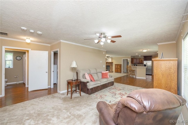 3737 Shelton Store Rd, Buckingham, VA 23921 - carpeted living room featuring ceiling fan, wood finished floors, a textured ceiling, crown molding, and a fireplace