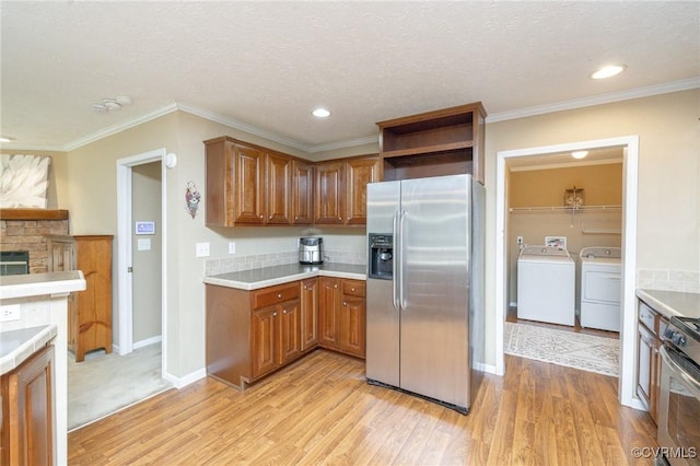 3737 Shelton Store Rd, Buckingham, VA 23921 - kitchen featuring appliances with stainless steel finishes, independent washer and dryer, light wood finished floors, brown cabinets, and light countertops
