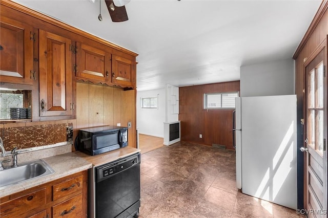 5425 Germain Rd, Richmond, VA 23224 - kitchen featuring black appliances, wood walls, brown cabinets, light countertops, and a ceiling fan