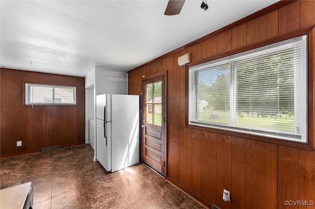 5425 Germain Rd, Richmond, VA 23224 - kitchen featuring freestanding refrigerator, wood walls, a ceiling fan, and brown cabinetry