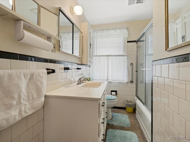5913 Ridge Rd, Henrico, VA 23227 - bathroom featuring tile walls, vanity, healthy amount of natural light, bath / shower combo with glass door, and a wainscoted wall