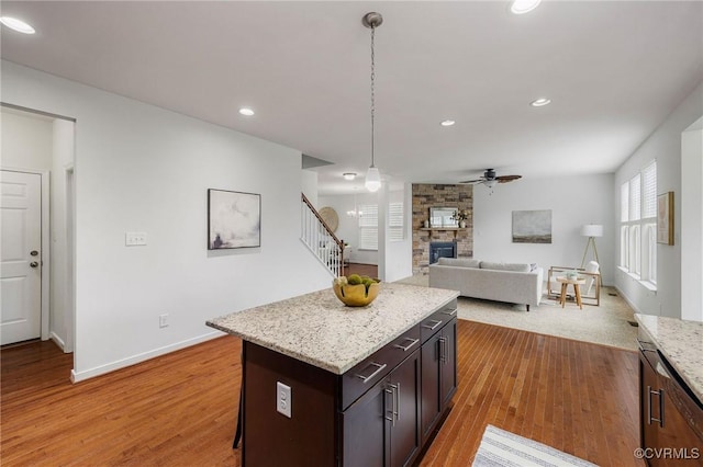 8838 Rushbrooke Ln, Mechanicsville, VA 23116 - kitchen with ceiling fan, a stone fireplace, light wood finished floors, recessed lighting, and decorative light fixtures