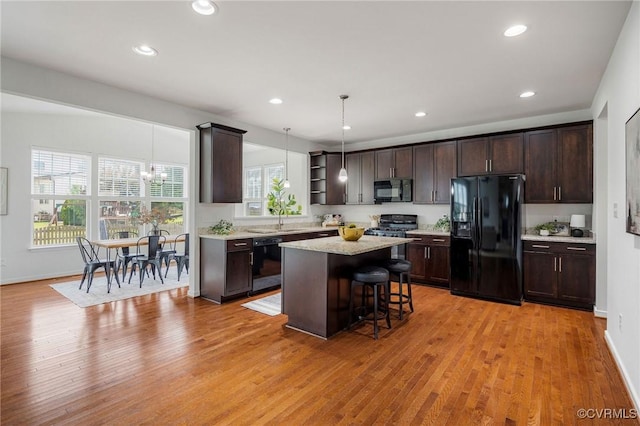 8838 Rushbrooke Ln, Mechanicsville, VA 23116 - kitchen featuring black appliances, open shelves, dark brown cabinetry, light wood-type flooring, and a breakfast bar area