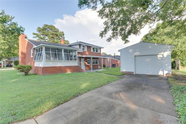 727 Teach St, Hampton, VA 23661 - view of front of house with a sunroom, a front lawn, concrete driveway, a chimney, and a detached garage