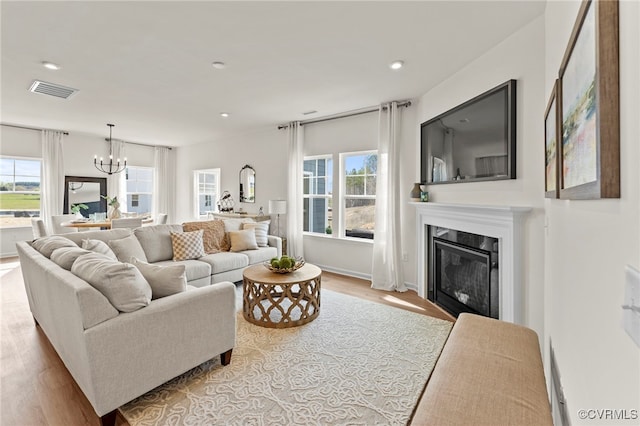 3417 Marwick Pl, Richmond, VA 23234 - living room featuring a chandelier, wood finished floors, a glass covered fireplace, and recessed lighting