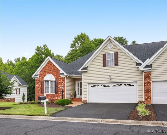 138 Carriage Point Ln, Glen Allen, VA 23059 - traditional home with asphalt driveway, brick siding, roof with shingles, and a front lawn