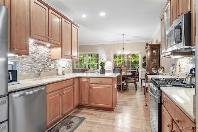 138 Carriage Point Ln, Glen Allen, VA 23059 - kitchen featuring appliances with stainless steel finishes, ornamental molding, light wood-style flooring, decorative backsplash, and a peninsula