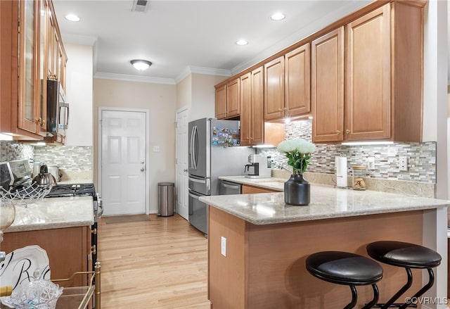 138 Carriage Point Ln, Glen Allen, VA 23059 - kitchen featuring a peninsula, stainless steel microwave, crown molding, light stone counters, and a kitchen bar