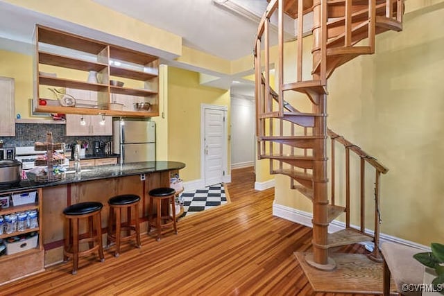 2024 Park Ave, Richmond, VA 23220 - kitchen with freestanding refrigerator, backsplash, a kitchen bar, light wood-style floors, and open shelves