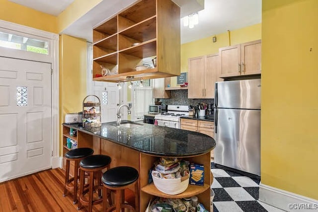 2024 Park Ave, Richmond, VA 23220 - kitchen featuring stainless steel appliances, open shelves, tasteful backsplash, and a breakfast bar