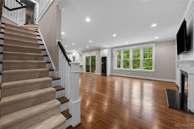 11499 Jack Ln, Hanover, VA 23146 - unfurnished living room featuring stairs, wood finished floors, a glass covered fireplace, healthy amount of natural light, and recessed lighting