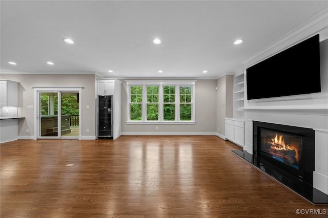 11499 Jack Ln, Hanover, VA 23146 - unfurnished living room featuring beverage cooler, a glass covered fireplace, ornamental molding, recessed lighting, and wood finished floors
