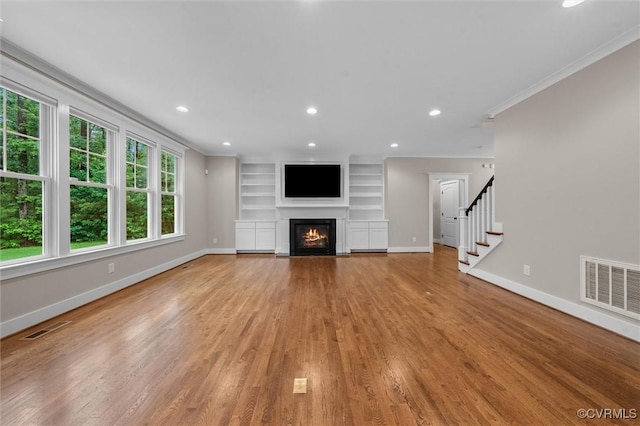 11499 Jack Ln, Hanover, VA 23146 - unfurnished living room with ornamental molding, a fireplace with flush hearth, light wood finished floors, recessed lighting, and built in shelves