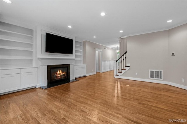 11499 Jack Ln, Hanover, VA 23146 - unfurnished living room with ornamental molding, a glass covered fireplace, light wood-style flooring, stairs, and built in features