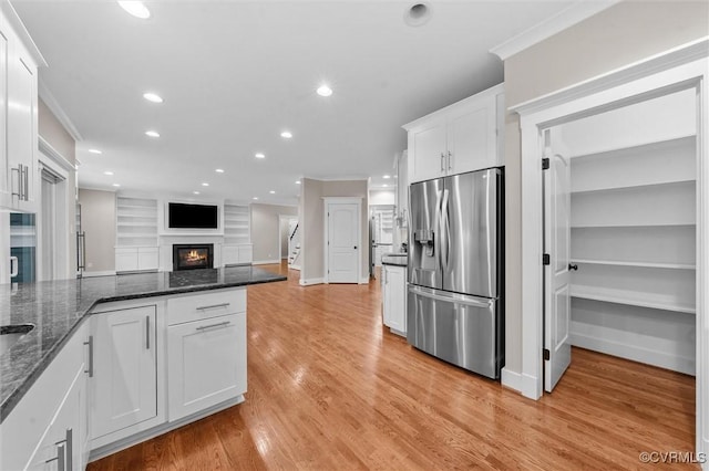 11499 Jack Ln, Hanover, VA 23146 - kitchen with stainless steel fridge, a warm lit fireplace, white cabinetry, recessed lighting, and ornamental molding