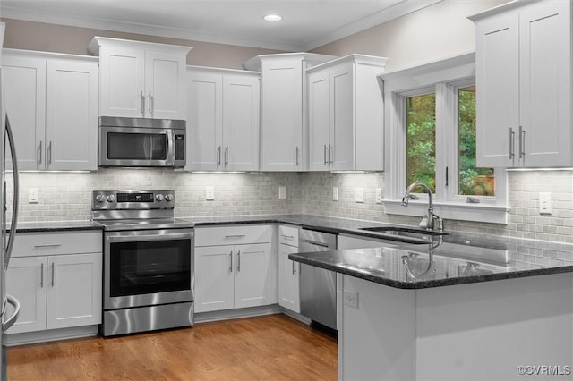 11499 Jack Ln, Hanover, VA 23146 - kitchen featuring stainless steel appliances, a peninsula, dark stone countertops, white cabinets, and crown molding